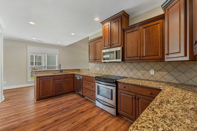 1032 Red Maple Way, Columbus, GA 31904 - kitchen with appliances with stainless steel finishes, ornamental molding, a sink, dark wood-type flooring, and backsplash
