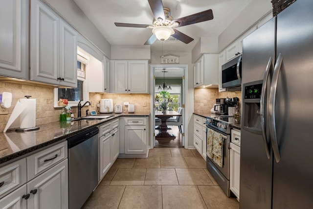 5936 Manassas Dr, Columbus, GA 31909 - kitchen featuring appliances with stainless steel finishes, ceiling fan, white cabinetry, tasteful backsplash, and light tile patterned floors