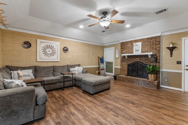 5936 Manassas Dr, Columbus, GA 31909 - living room featuring wood finished floors, a ceiling fan, a fireplace, and a raised ceiling
