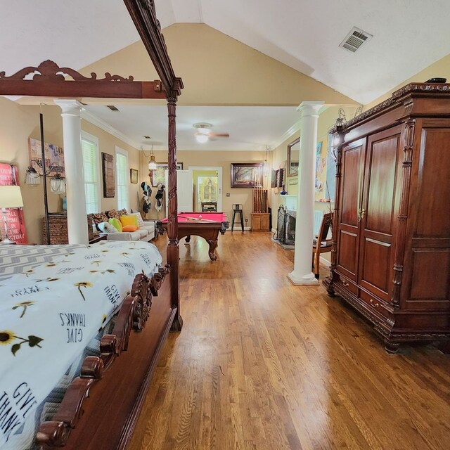 bedroom featuring wood-type flooring, multiple windows, lofted ceiling, and pool table