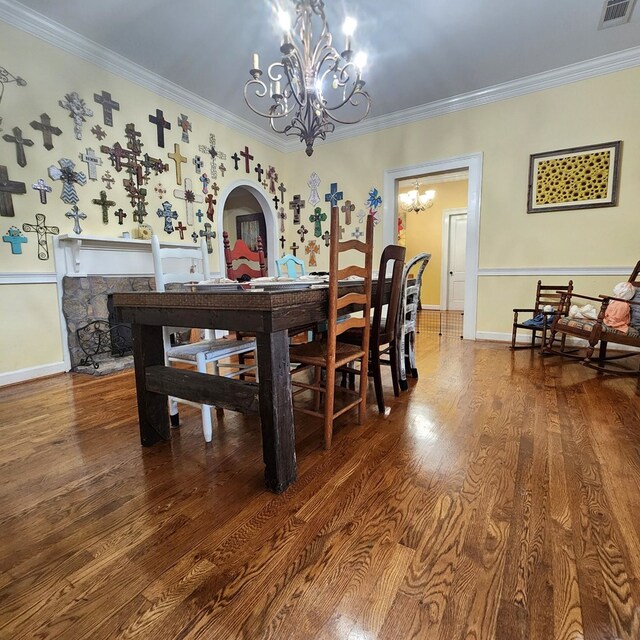 dining room featuring hardwood / wood-style floors, ornamental molding, and an inviting chandelier