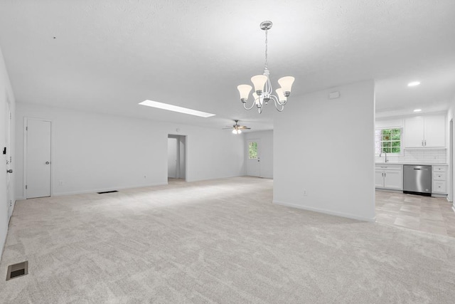 carpeted spare room with sink and ceiling fan with notable chandelier