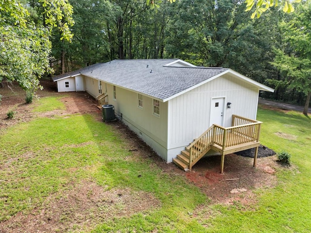 rear view of house featuring a lawn and central AC unit