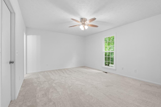 carpeted empty room with a textured ceiling and ceiling fan