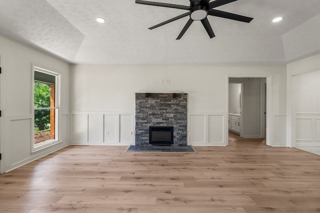 766 Lee Road 0553, Phenix City, AL 36870 - unfurnished living room with a decorative wall, ceiling fan, a textured ceiling, light wood-style floors, and a fireplace