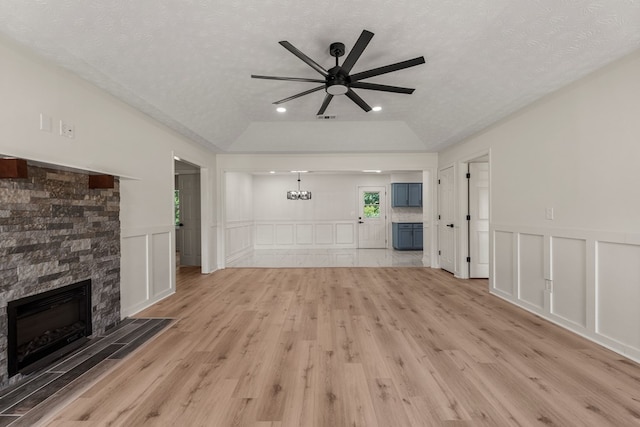 766 Lee Road 0553, Phenix City, AL 36870 - unfurnished living room with a ceiling fan, light wood finished floors, a decorative wall, a fireplace, and a textured ceiling