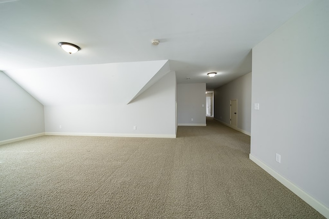 additional living space featuring carpet floors and vaulted ceiling