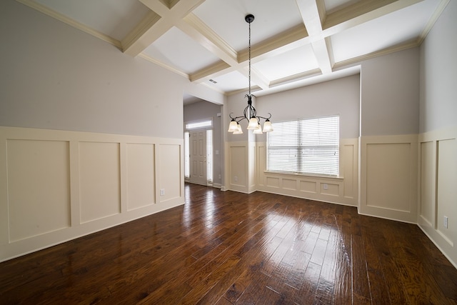 unfurnished dining area with dark wood-type flooring, coffered ceiling, ornamental molding, beamed ceiling, and a chandelier