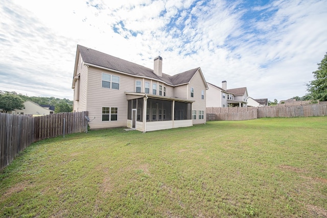 back of property with a lawn and a sunroom