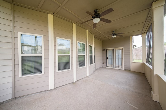 unfurnished sunroom featuring ceiling fan