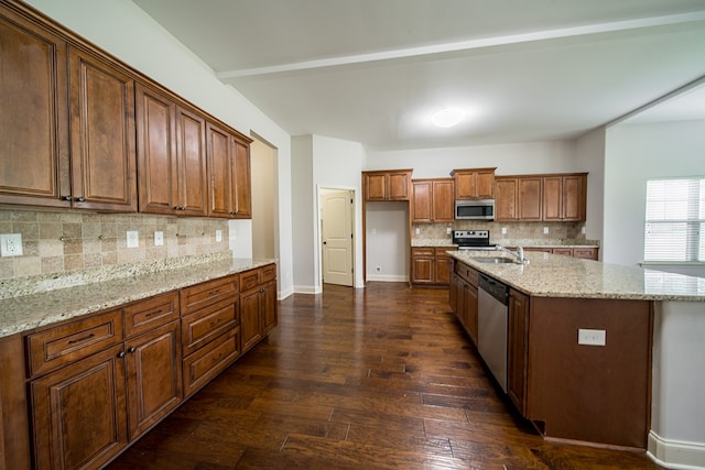 kitchen featuring decorative backsplash, appliances with stainless steel finishes, light stone countertops, dark wood-type flooring, and sink