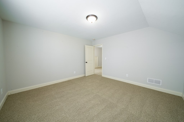 empty room featuring carpet flooring and vaulted ceiling