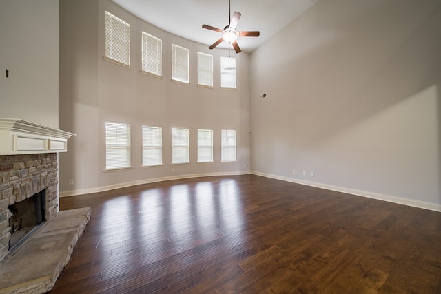 unfurnished living room with a fireplace, high vaulted ceiling, and dark wood-type flooring