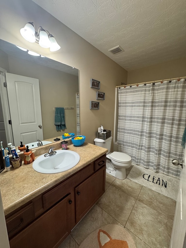 full bathroom featuring visible vents, toilet, vanity, tile patterned floors, and a textured ceiling