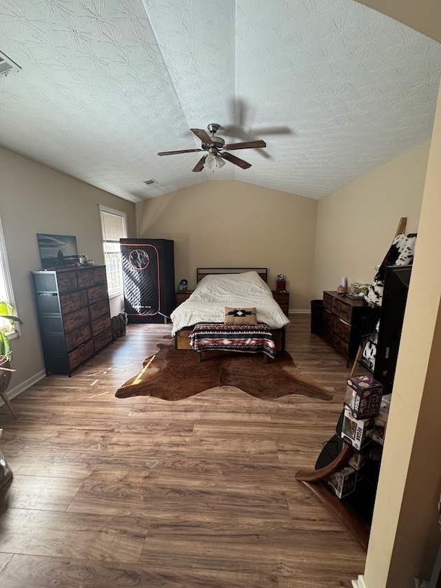 bedroom featuring lofted ceiling, wood finished floors, and baseboards