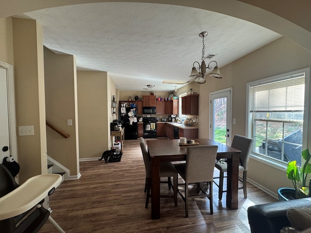 dining area featuring visible vents, dark wood finished floors, stairs, and a chandelier