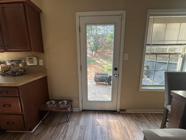 doorway with wood finished floors and baseboards