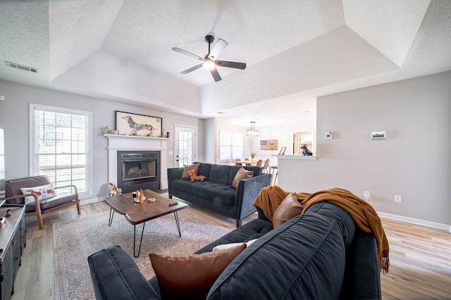 5082 Aaron Ln, Columbus, GA 31907 - living area with a raised ceiling, light wood-style flooring, a ceiling fan, healthy amount of natural light, and a textured ceiling