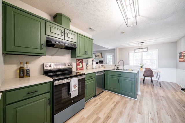5082 Aaron Ln, Columbus, GA 31907 - kitchen featuring appliances with stainless steel finishes, under cabinet range hood, a peninsula, a textured ceiling, and green cabinets