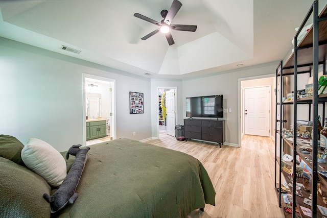 5082 Aaron Ln, Columbus, GA 31907 - bedroom with a tray ceiling, light wood-style flooring, connected bathroom, and a ceiling fan