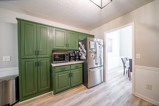 5082 Aaron Ln, Columbus, GA 31907 - kitchen featuring stainless steel appliances, green cabinets, light wood-style flooring, light countertops, and a textured ceiling