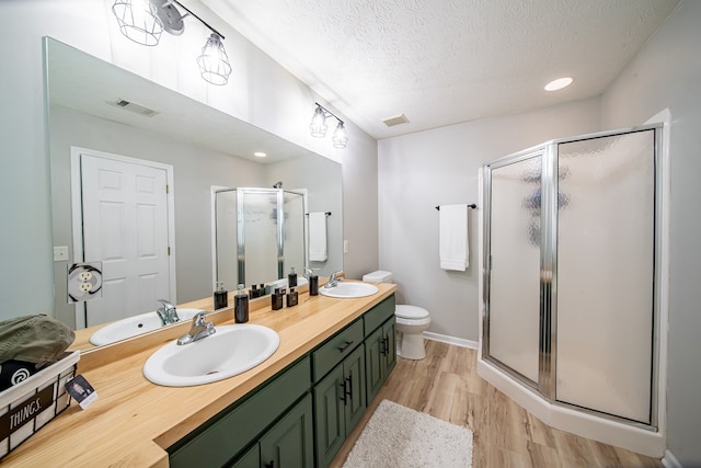 5082 Aaron Ln, Columbus, GA 31907 - bathroom featuring wood finished floors, a stall shower, double vanity, a textured ceiling, and recessed lighting