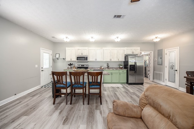 170 Slappy Dr, Hamilton, GA 31811 - kitchen with stainless steel appliances, light wood-style flooring, a textured ceiling, and open floor plan
