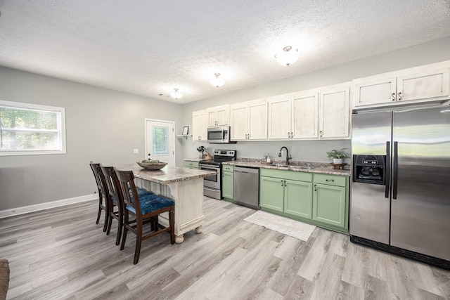 170 Slappy Dr, Hamilton, GA 31811 - kitchen featuring appliances with stainless steel finishes, green cabinets, a textured ceiling, healthy amount of natural light, and light wood-style floors