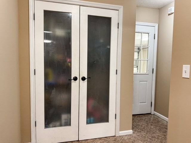 interior space with french doors and baseboards