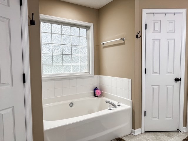 bathroom with a healthy amount of sunlight and a bath