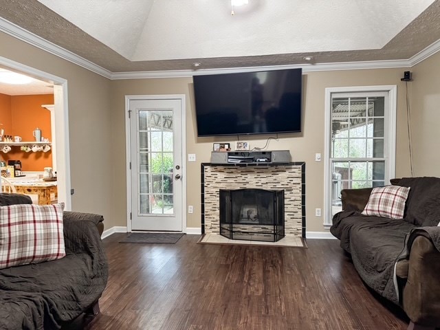 living area with a tray ceiling, plenty of natural light, a textured ceiling, and wood finished floors