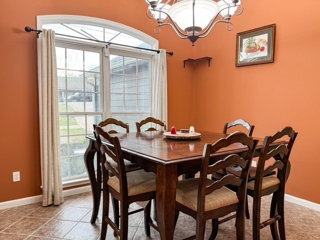 dining area with a wealth of natural light, baseboards, and light tile patterned floors