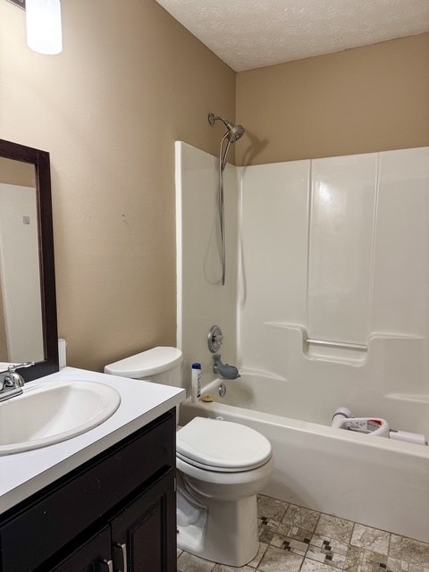 bathroom with vanity, toilet, tub / shower combination, and a textured ceiling