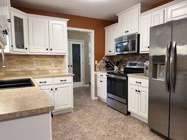 kitchen with light countertops, white cabinets, and appliances with stainless steel finishes