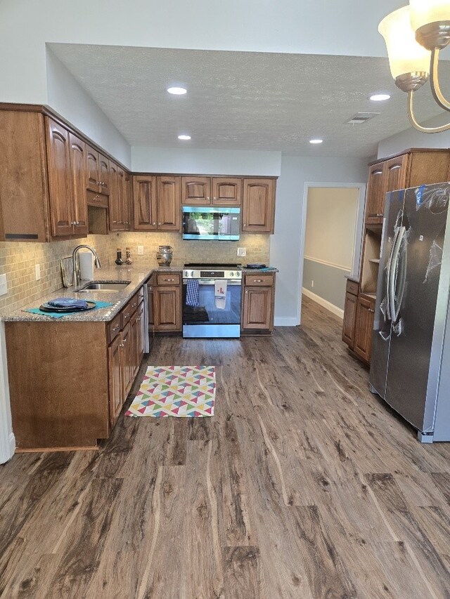 4044 Castlewood Pkwy, Columbus, GA 31907 - kitchen featuring stainless steel appliances, a sink, baseboards, dark wood-style flooring, and decorative backsplash