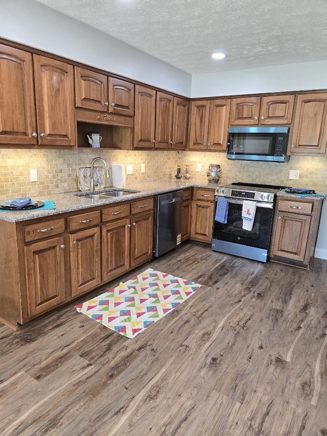 4044 Castlewood Pkwy, Columbus, GA 31907 - kitchen featuring stainless steel appliances, a sink, dark wood-type flooring, a textured ceiling, and tasteful backsplash