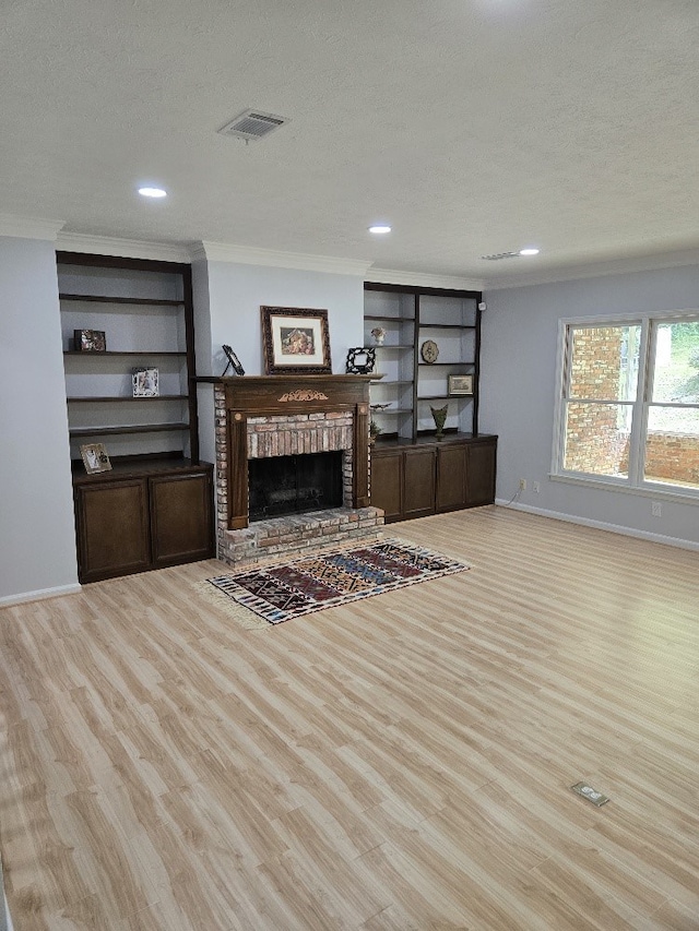 4044 Castlewood Pkwy, Columbus, GA 31907 - living area featuring wood finished floors, ornamental molding, a textured ceiling, a brick fireplace, and baseboards