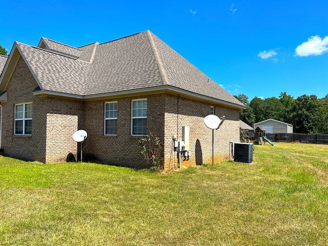 view of home's exterior with central air condition unit and a yard