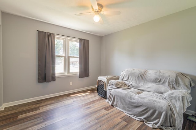 living area featuring ceiling fan and dark wood-type flooring