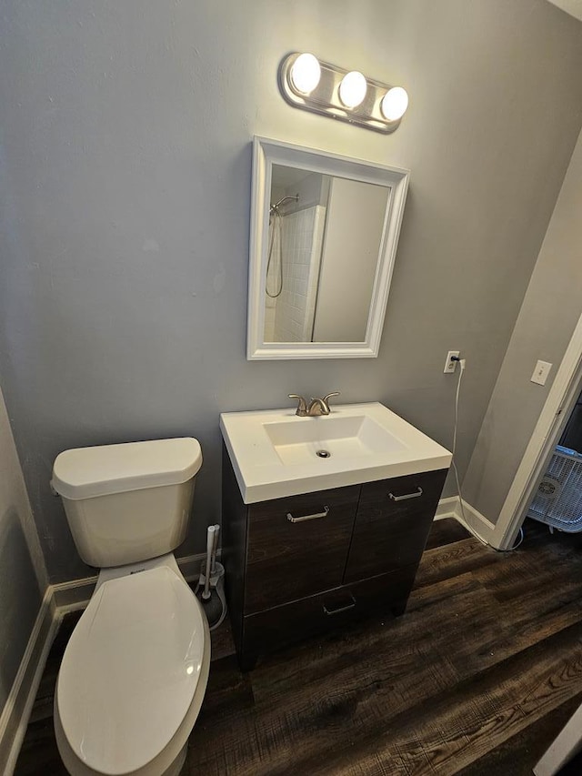 bathroom with hardwood / wood-style floors, vanity, and toilet