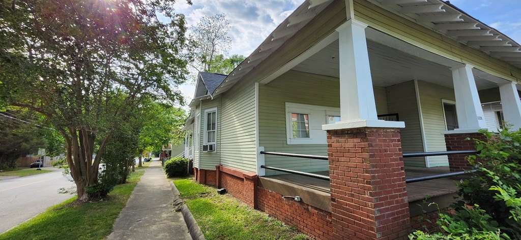 view of home's exterior featuring brick siding and a porch