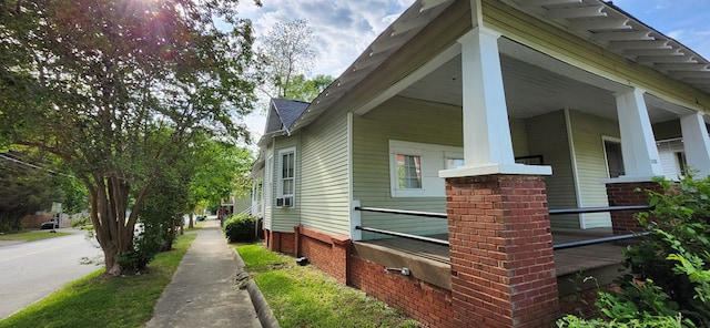 view of home's exterior featuring brick siding and a porch