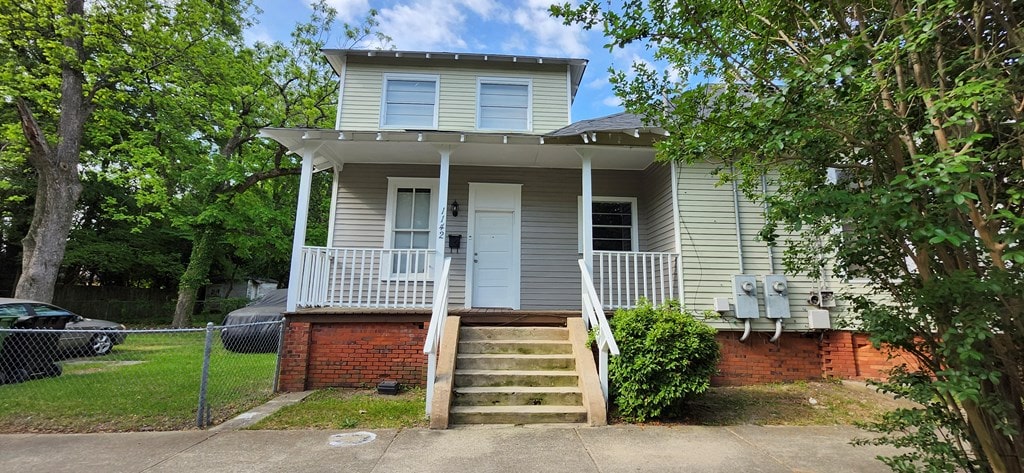view of front facade with fence and a porch