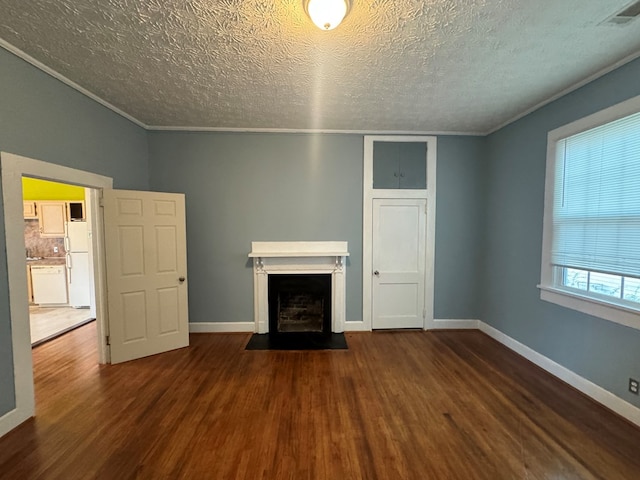unfurnished living room featuring a fireplace with flush hearth, a textured ceiling, wood finished floors, and visible vents