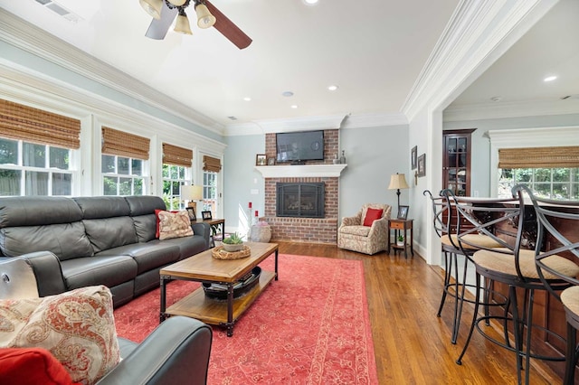 living room with hardwood / wood-style floors, crown molding, and a wealth of natural light