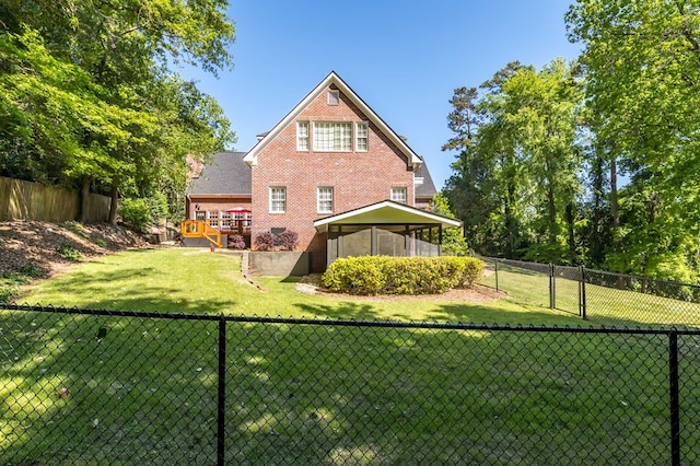 rear view of property with a sunroom, a yard, and a deck