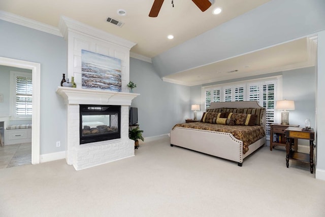 carpeted bedroom featuring connected bathroom, a brick fireplace, ceiling fan, and ornamental molding