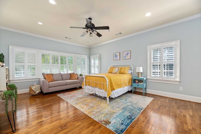 bedroom with hardwood / wood-style flooring, multiple windows, ornamental molding, and ceiling fan