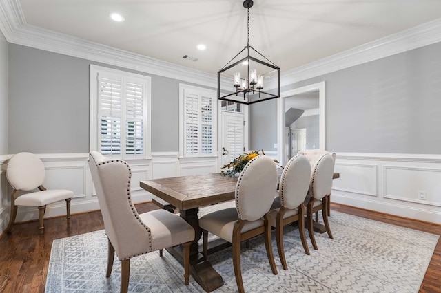 dining space featuring crown molding, dark hardwood / wood-style flooring, and a chandelier