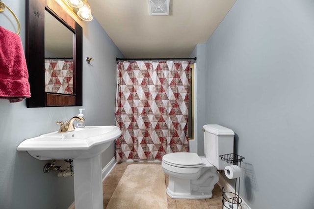 bathroom with tile patterned flooring, toilet, and shower / bathtub combination with curtain